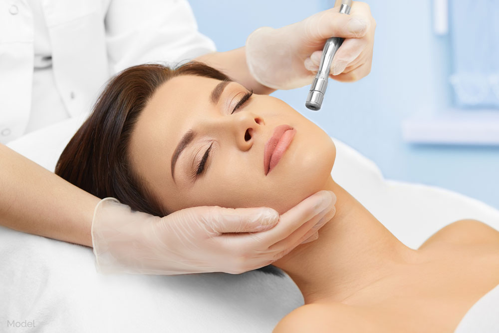 female model having her face examined by a doctor's gloved hands