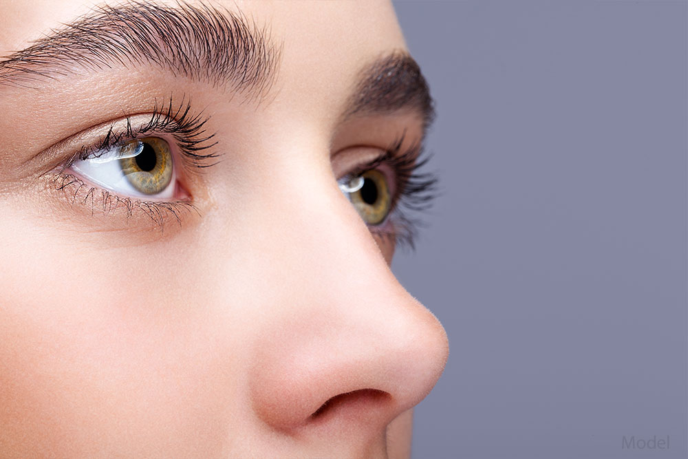 Close up of a woman's light brown eyes and small nose