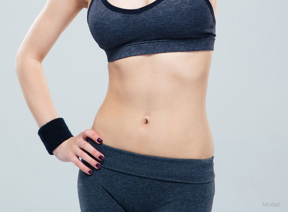 Midbody shot of a woman with a slim waist while wearing athletic wear