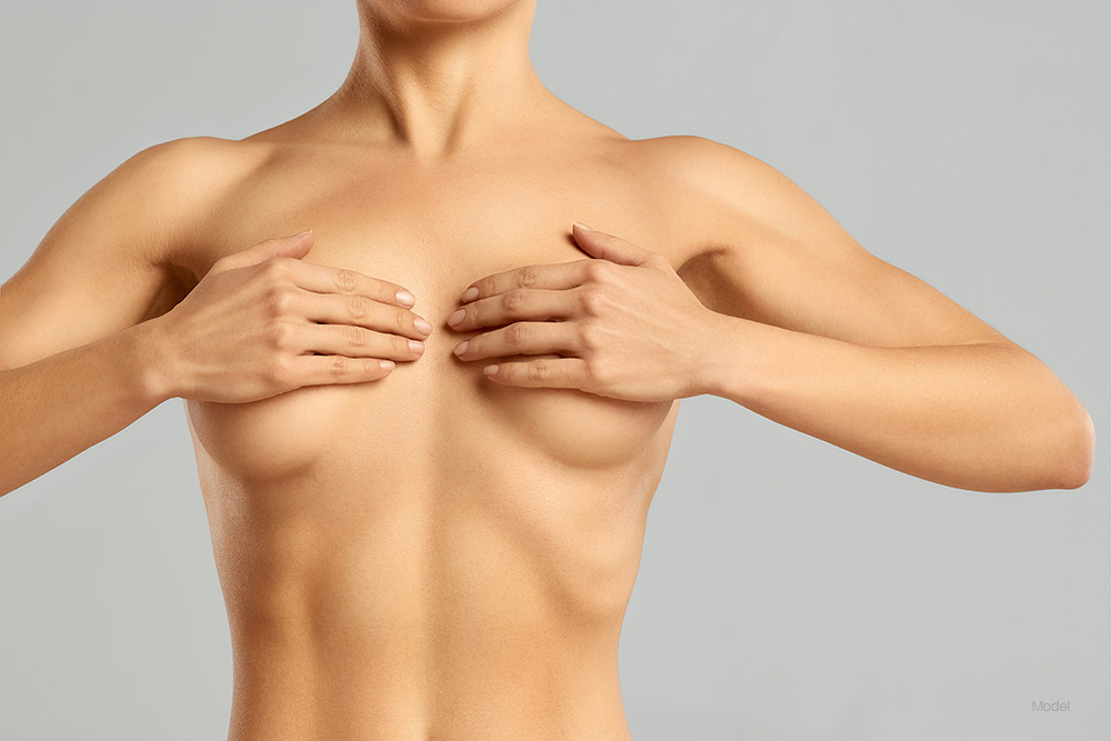 Woman covering her breast with her hands